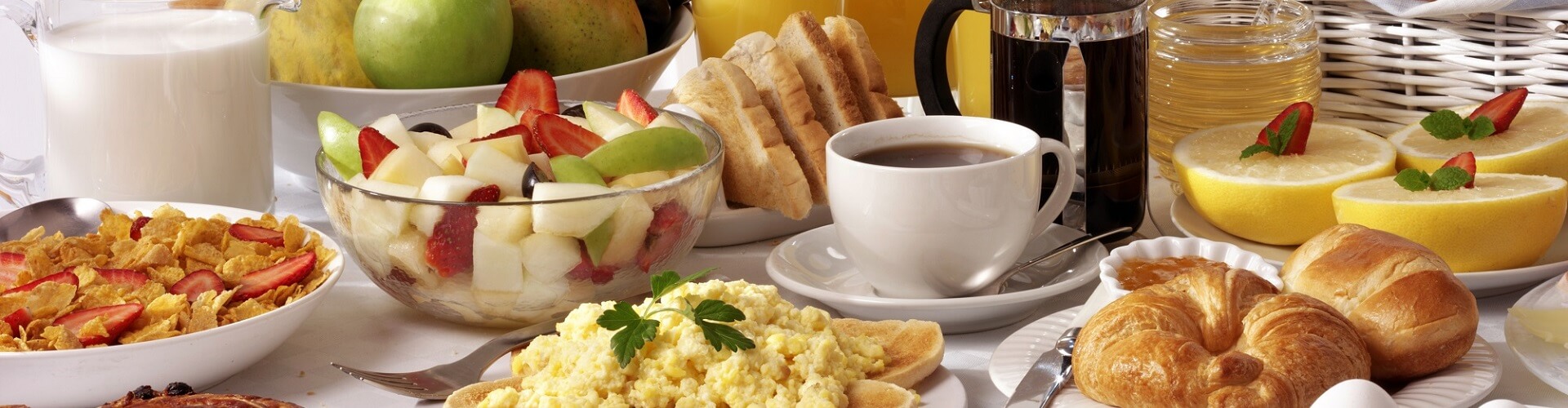 BREAKFAST BUFFET TABLE FILLED WITH ASSORTED FOODS,SAVOURY,SWEET,PASTRIES,HOT AND COLD DRINKS